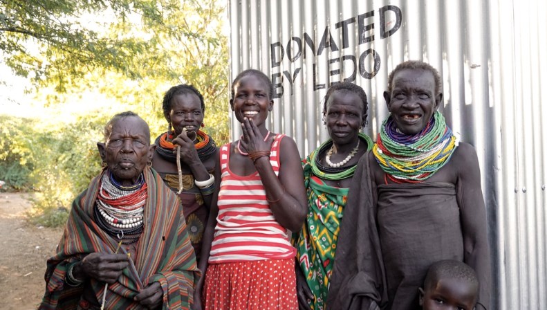 Margret Kimokoe tillsammans med några av grannarna, sammanlagt c:a 20 personer som använder den nya latrinen